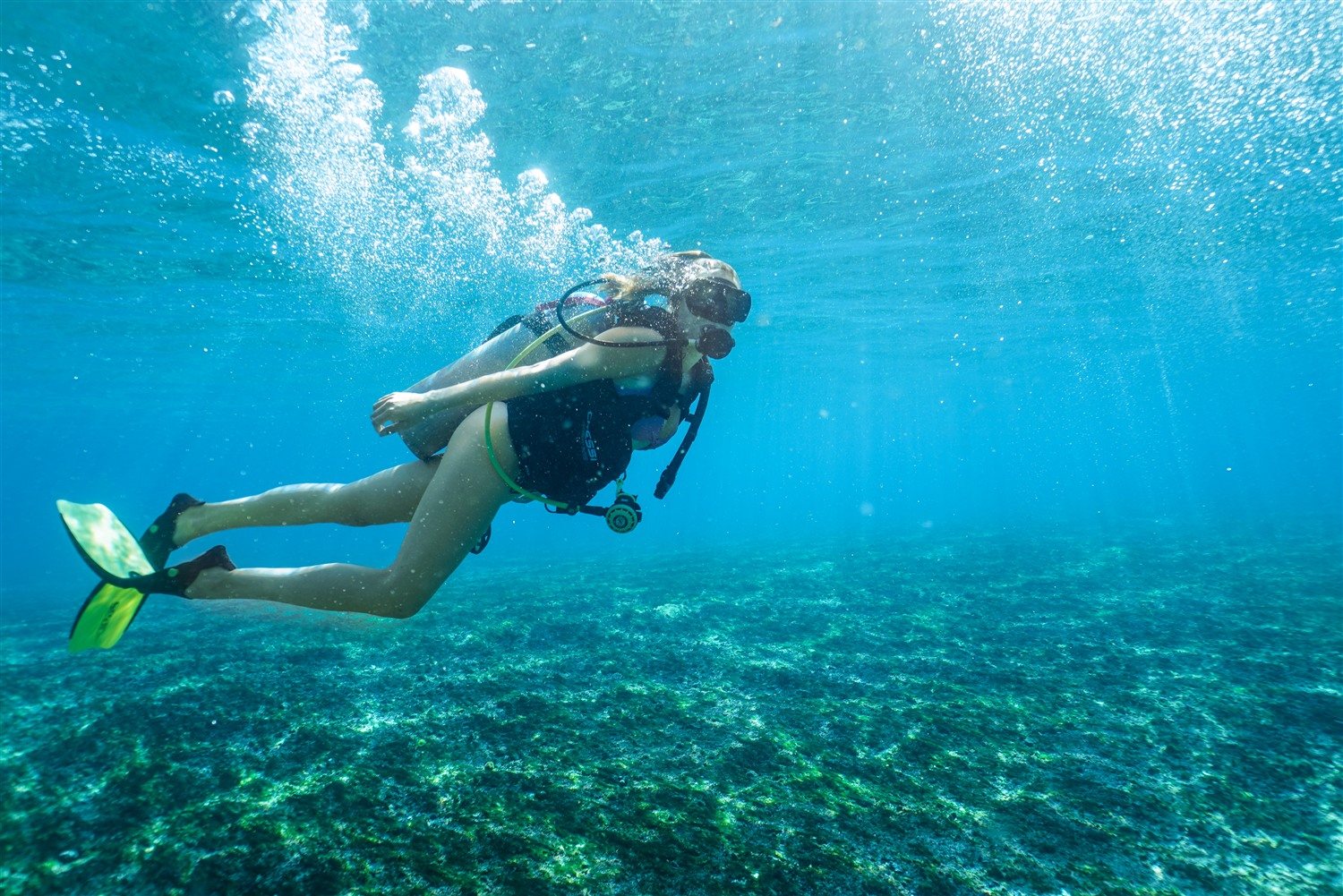 Diver descending into clear blue water off Tamarindo, Costa Rica