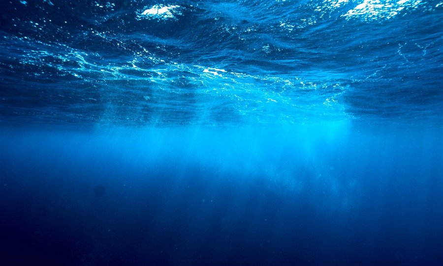 Sun rays through clear blue water off Tamarindo