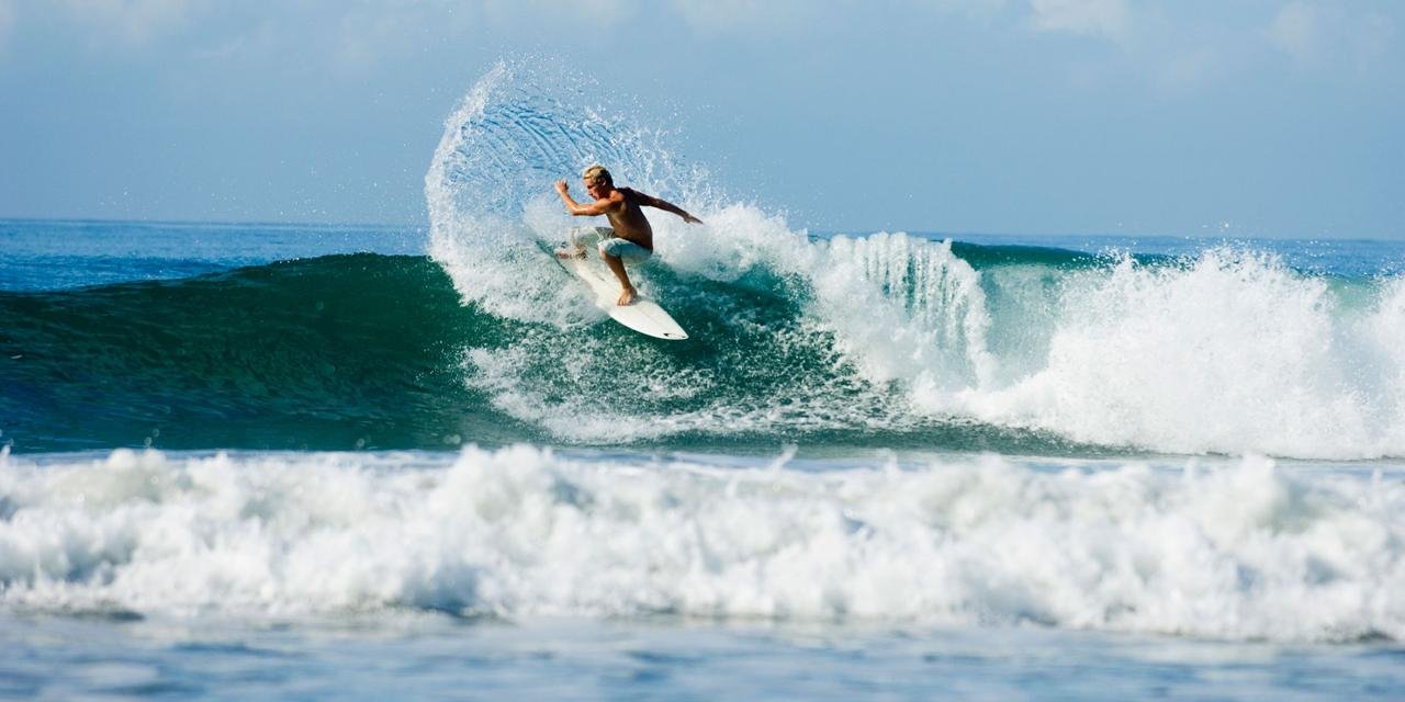 Surfer riding a wave near Tamarindo, Costa Rica